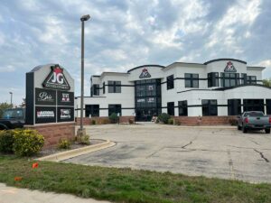 white office building with dark windows and signs